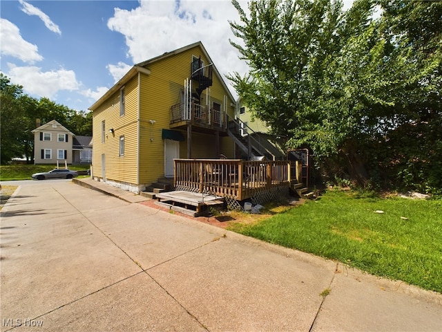 view of front facade with a wooden deck and a front yard