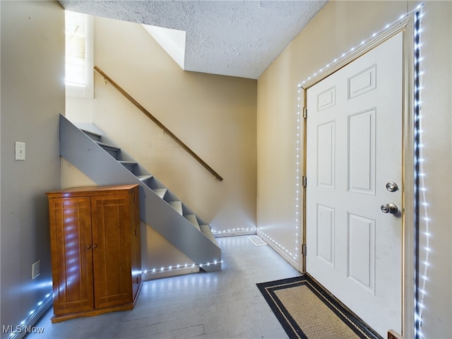 entryway with light hardwood / wood-style flooring and a textured ceiling