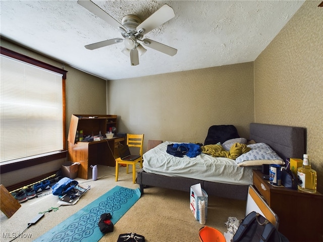 bedroom featuring ceiling fan, a textured ceiling, and carpet flooring