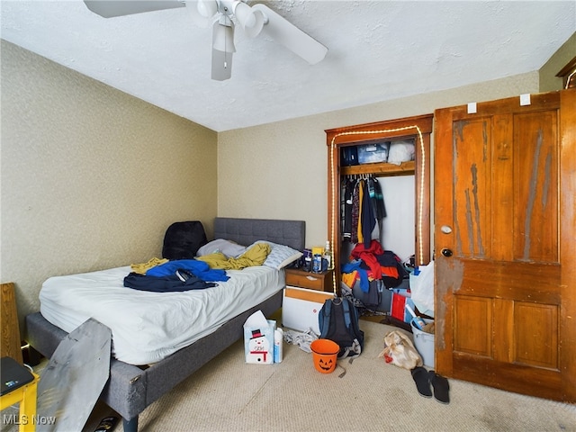 bedroom with ceiling fan, carpet flooring, and a closet