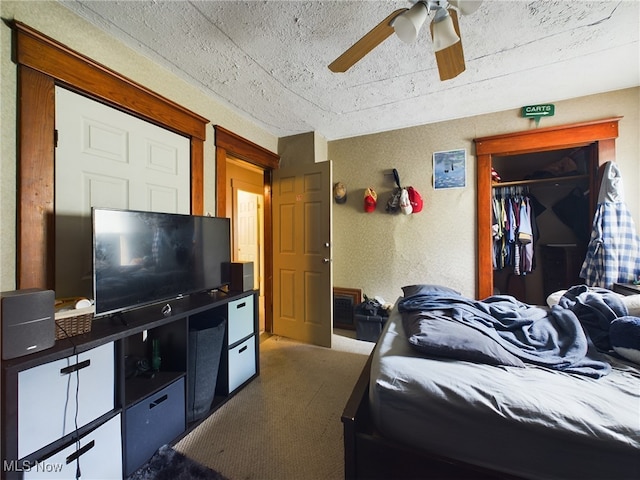 bedroom with ceiling fan, a textured ceiling, a closet, and carpet