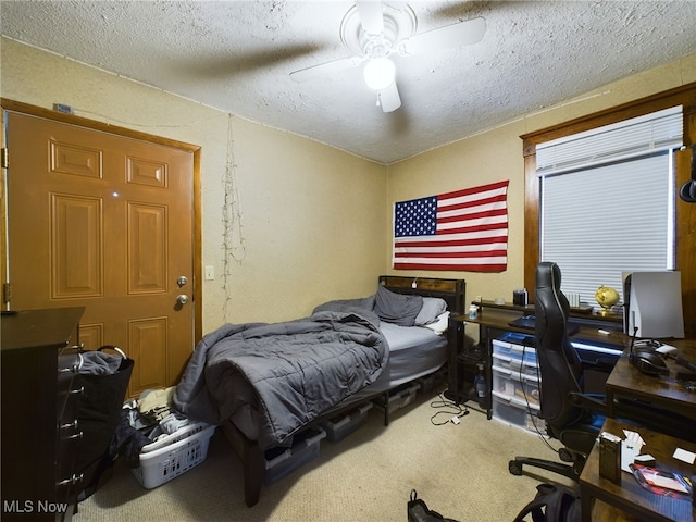 bedroom with ceiling fan, a textured ceiling, and carpet floors