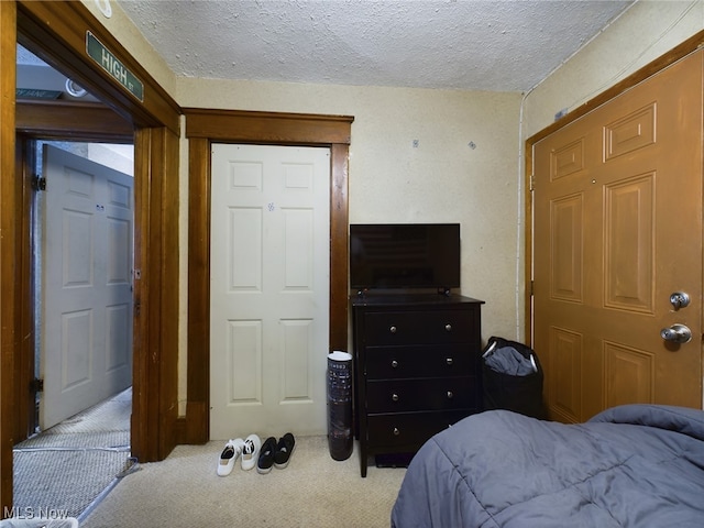 bedroom featuring a textured ceiling and carpet flooring