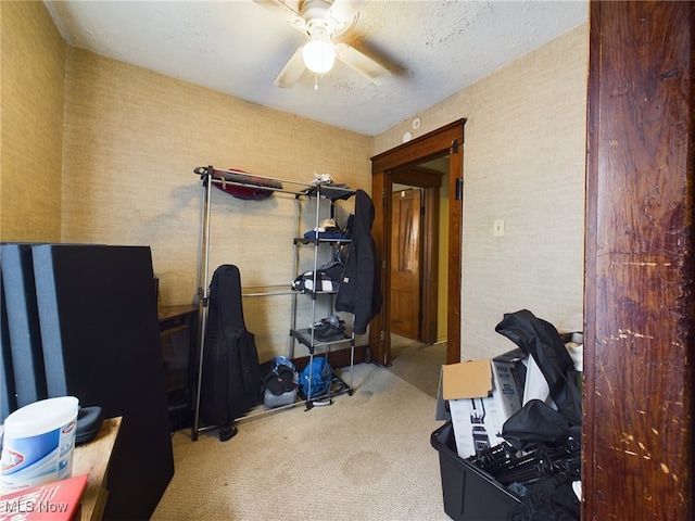 miscellaneous room with ceiling fan, a textured ceiling, and carpet flooring