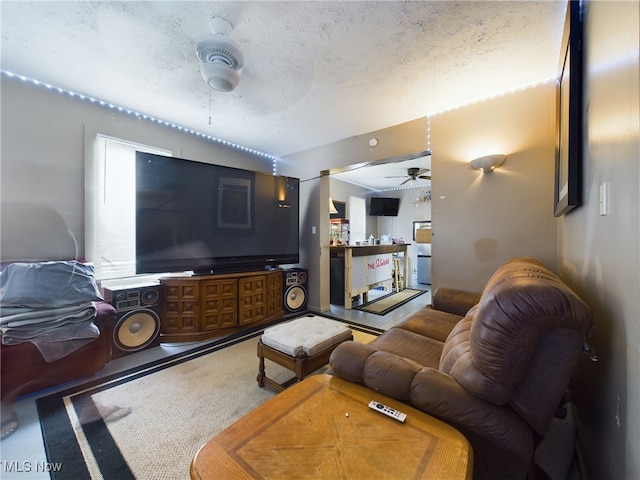 living room featuring ceiling fan and a textured ceiling