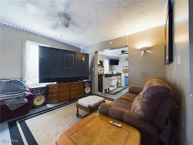 living room with a textured ceiling and ceiling fan