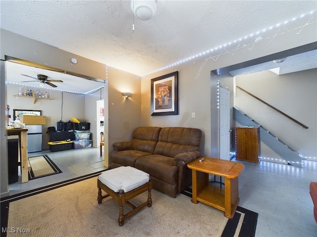 living room featuring a textured ceiling and ceiling fan