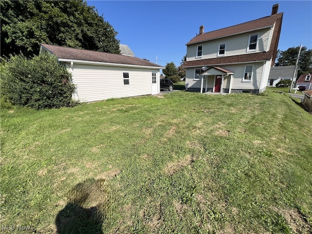 rear view of house featuring a lawn