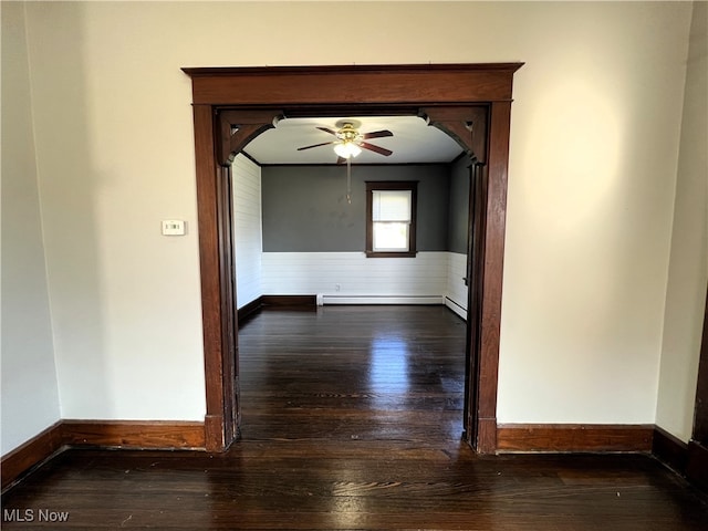 spare room featuring ceiling fan, wood-type flooring, and baseboard heating