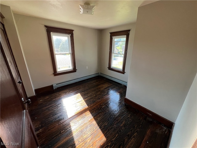 unfurnished room with a baseboard radiator, dark hardwood / wood-style floors, and plenty of natural light