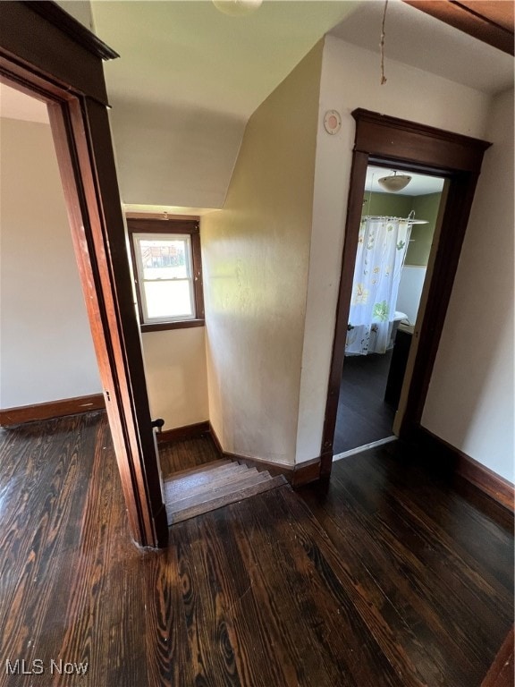 staircase with vaulted ceiling and hardwood / wood-style flooring