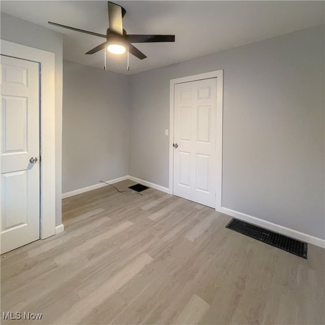 unfurnished bedroom with ceiling fan and light wood-type flooring