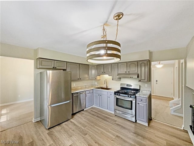 kitchen featuring appliances with stainless steel finishes, light hardwood / wood-style floors, gray cabinetry, and sink