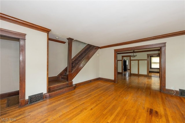 unfurnished living room featuring hardwood / wood-style flooring and ornamental molding