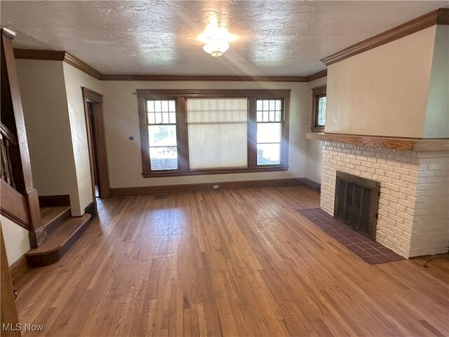 2572-2574 Mayfield Rd, Cleveland Heights, OH 44106 - unfurnished living room with light wood finished floors, a brick fireplace, and ornamental molding
