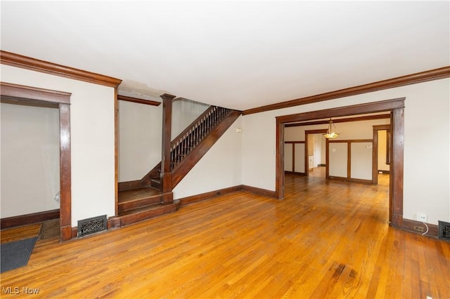 unfurnished living room featuring crown molding and wood-type flooring