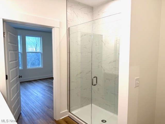 bathroom featuring wood-type flooring and a shower with shower door