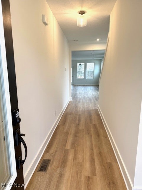 corridor with light hardwood / wood-style floors