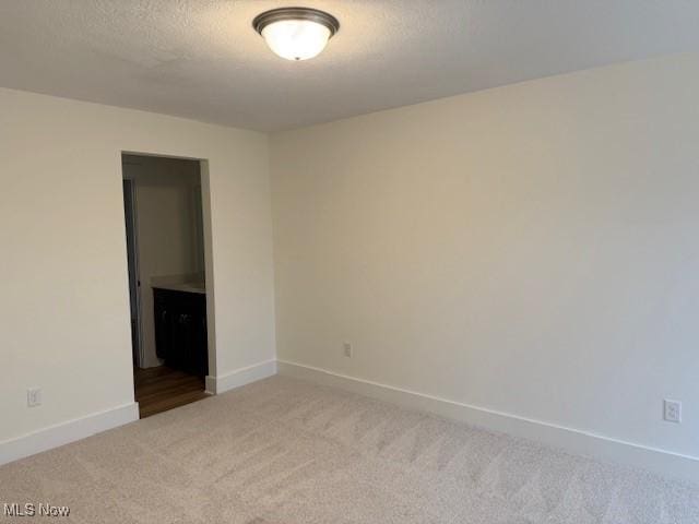 carpeted spare room featuring a textured ceiling