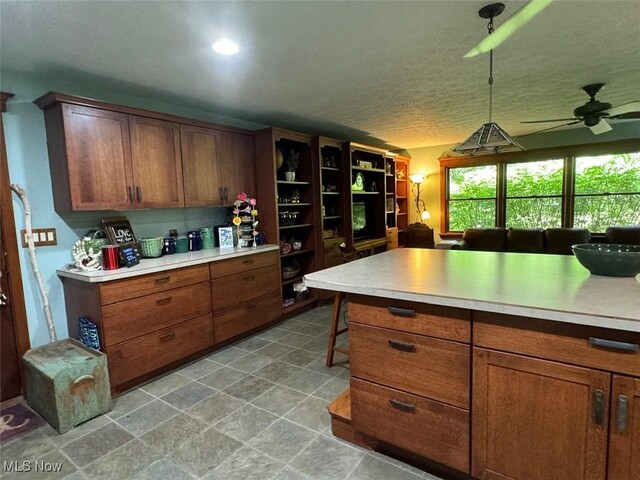 kitchen featuring ceiling fan, light tile patterned floors, and hanging light fixtures