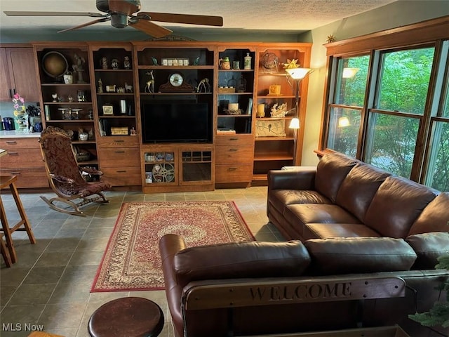 tiled living room with ceiling fan and a textured ceiling