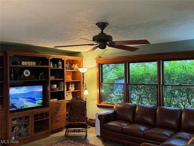 tiled living room with ceiling fan and a textured ceiling