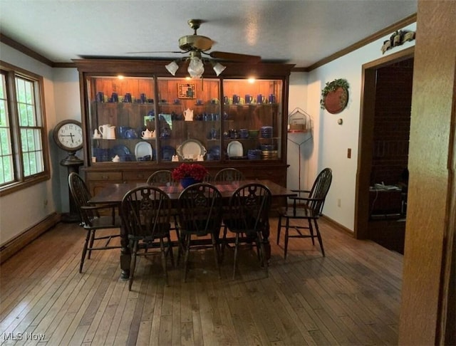 dining space featuring crown molding, wood-type flooring, and ceiling fan