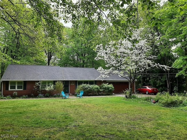 ranch-style home featuring a garage and a front lawn