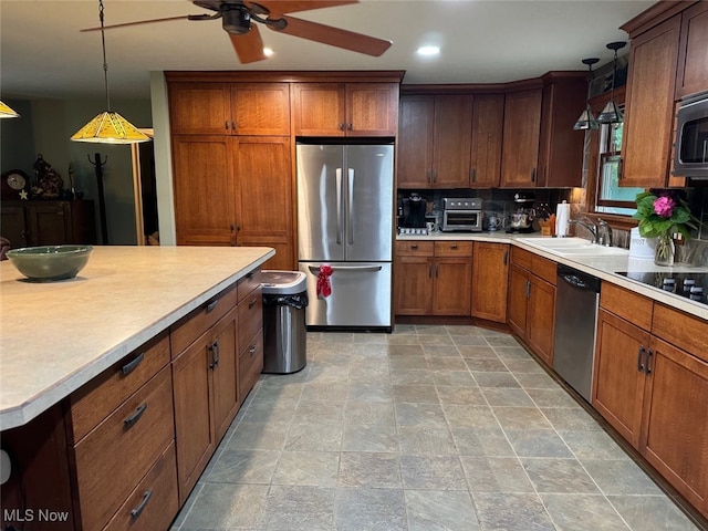 kitchen featuring ceiling fan, hanging light fixtures, light tile patterned floors, sink, and stainless steel appliances