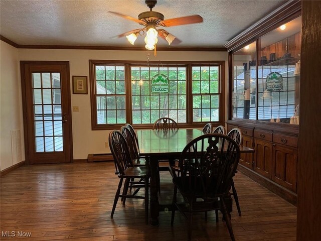 dining area with a wealth of natural light, crown molding, and dark wood-type flooring