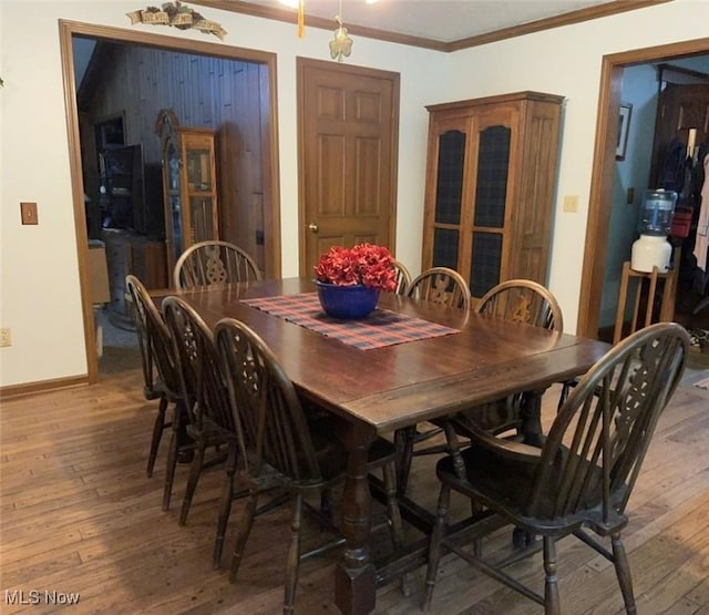 dining area with crown molding and hardwood / wood-style floors