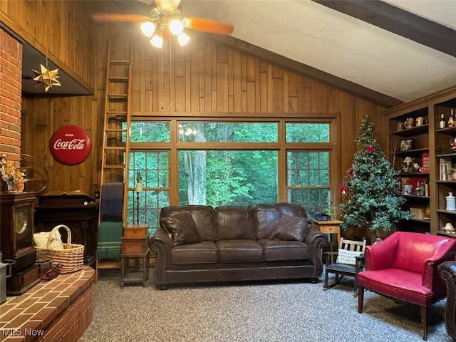 carpeted living room featuring ceiling fan, wooden walls, and vaulted ceiling