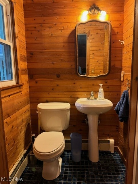 bathroom with toilet, wooden walls, and tile patterned floors