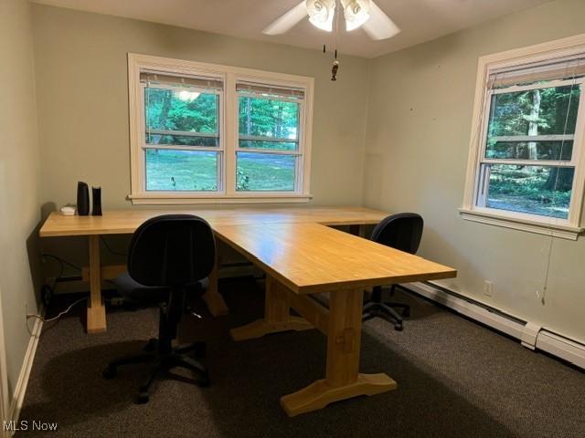 home office with plenty of natural light, a baseboard heating unit, carpet, and ceiling fan