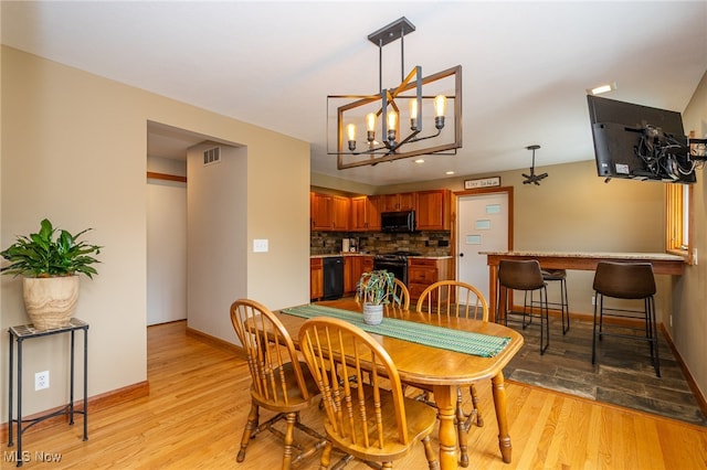 dining room with light hardwood / wood-style floors and an inviting chandelier