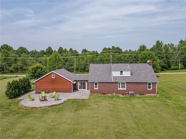 view of front of home featuring a front lawn, central AC unit, and a patio