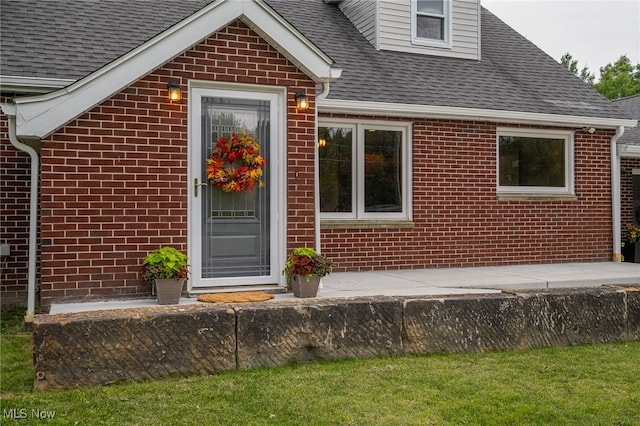 doorway to property featuring a lawn