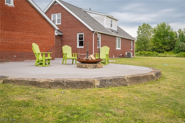 rear view of house with a lawn, central AC unit, and a patio area