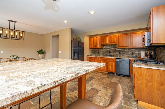 kitchen featuring backsplash, stainless steel appliances, decorative light fixtures, dark tile patterned flooring, and light stone countertops