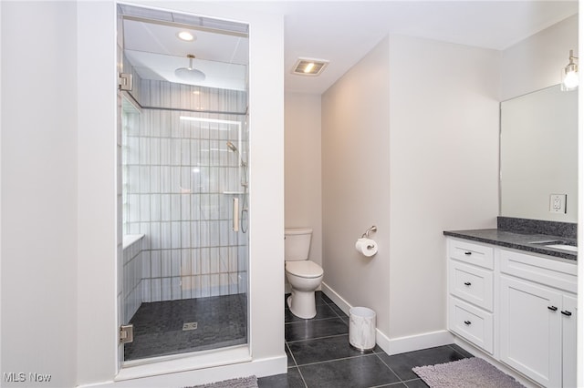 bathroom featuring tile patterned flooring, toilet, a shower with shower door, and vanity