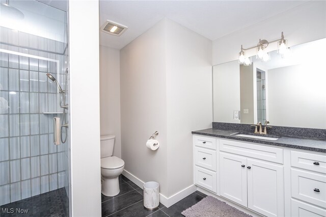 bathroom featuring toilet, an enclosed shower, tile patterned flooring, and vanity