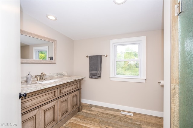 bathroom featuring hardwood / wood-style flooring, vanity, and lofted ceiling