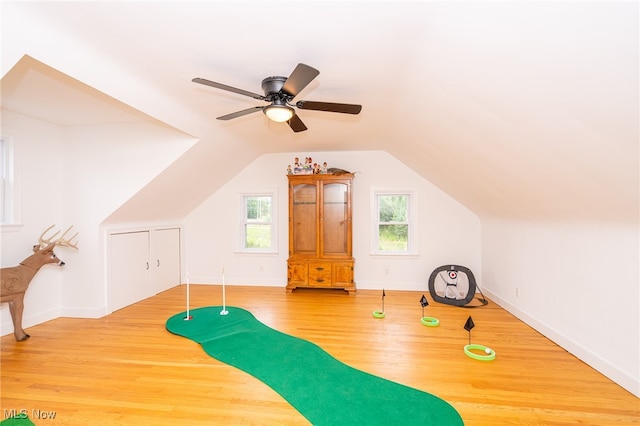 exercise room featuring ceiling fan, vaulted ceiling, and light hardwood / wood-style flooring