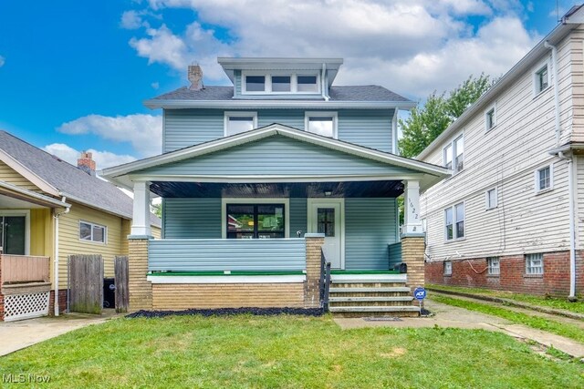 view of front of house with a front yard and covered porch