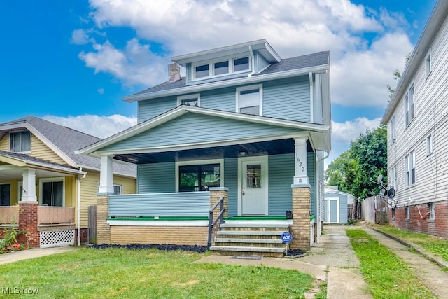 craftsman house featuring covered porch and a front yard