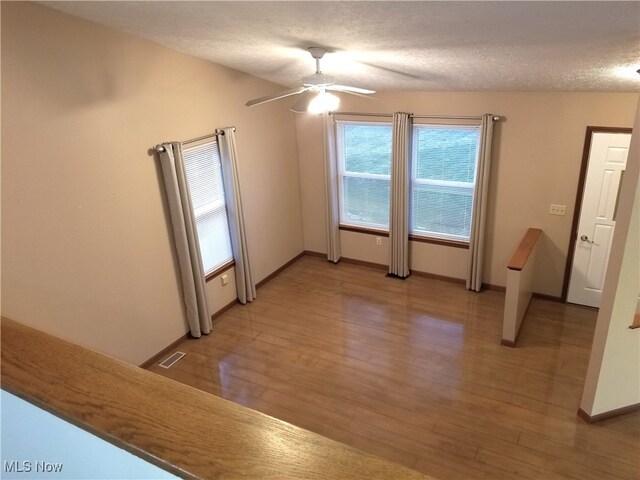 spare room with a textured ceiling and hardwood / wood-style flooring