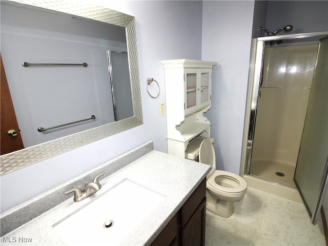 bathroom with a shower with shower door, vanity, and toilet