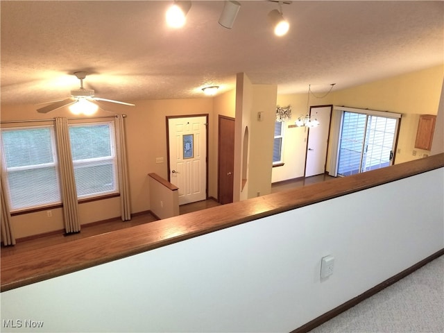 hall featuring a chandelier and a textured ceiling