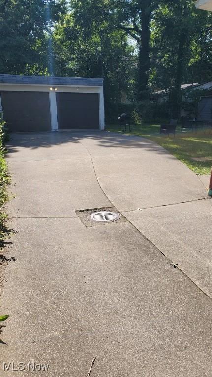 garage featuring concrete driveway