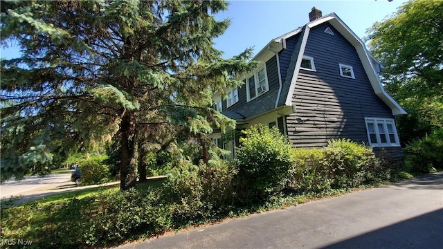 view of home's exterior featuring a chimney and a gambrel roof